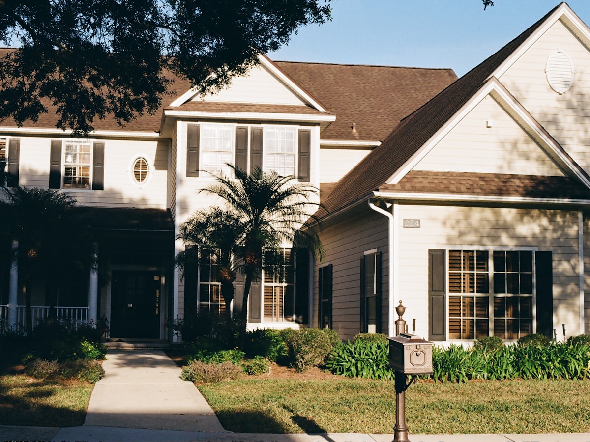A two-storey house with a covered porch and a tidy front yard
