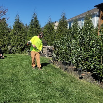 A groundskeeper mowing stripes into a wide green lawn