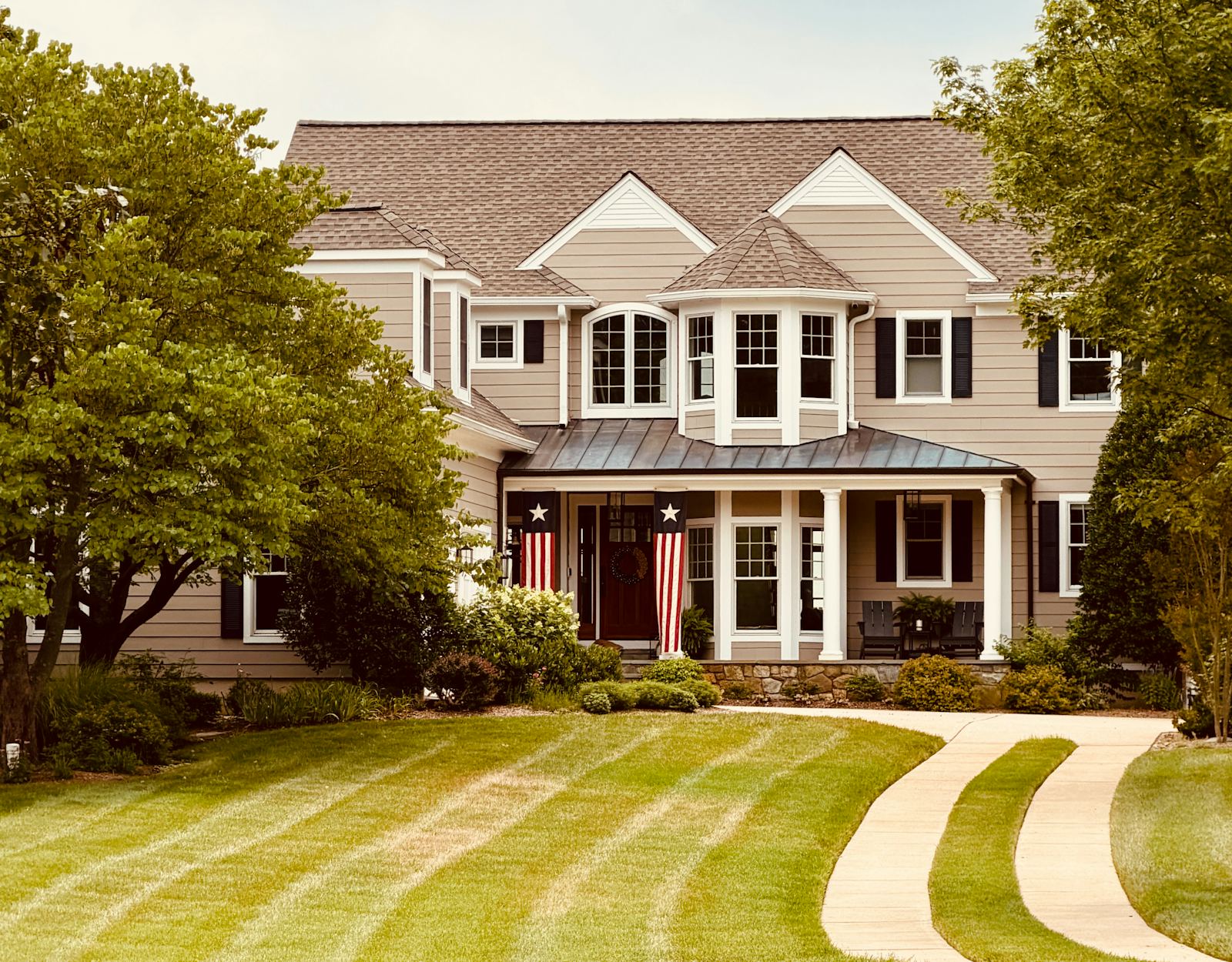 A large family home with a curved driveway and a freshly cut front lawn
